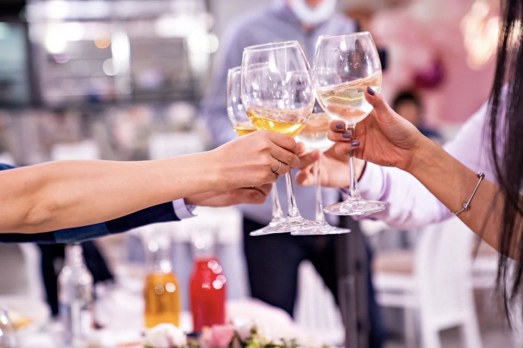 Eine Gruppe von Menschen stößt mit Alkohol in Gläsern an