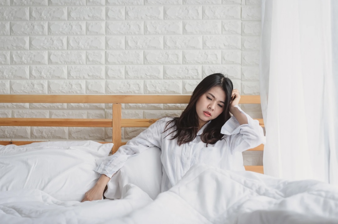 Junge Frau abgeschlagen und müde im Bett