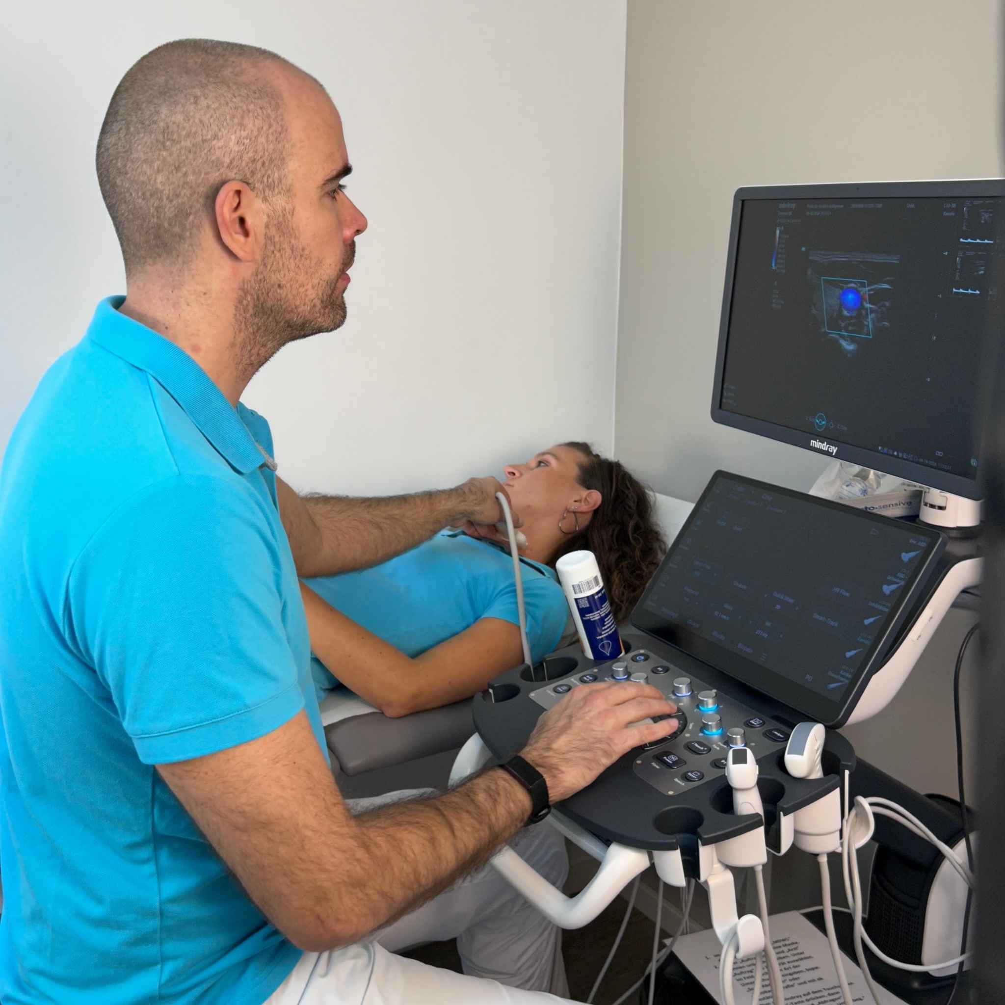 Frau unterzieht sich einer Sonografie der Halsgefäße zur Untersuchung der Halsschlagadern durch eine Ärztin mit einem Ultraschallgerät.