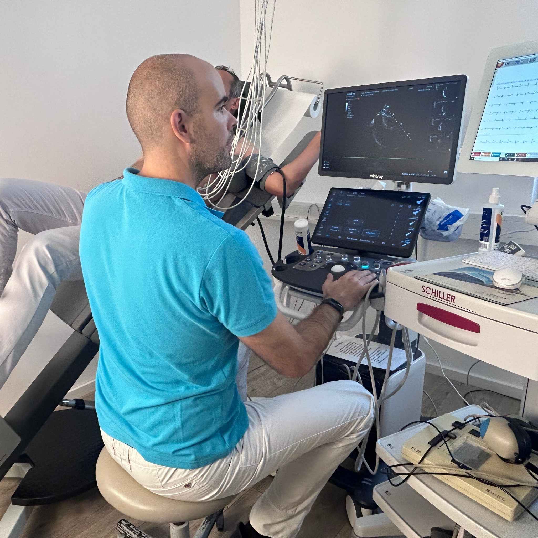 Patient führt ein Belastungs-EKG unter ärztlicher Aufsicht durch, während Blutdruck und Herzfunktion überwacht werden.